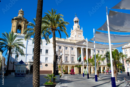 Historical building of Town Hall with a clock tower, columns and arcade, Plaza de San Juan de Dios, Cadiz, Spain. photo