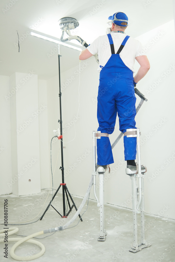 Painter work with ceiling. polishing and sanding the surface after