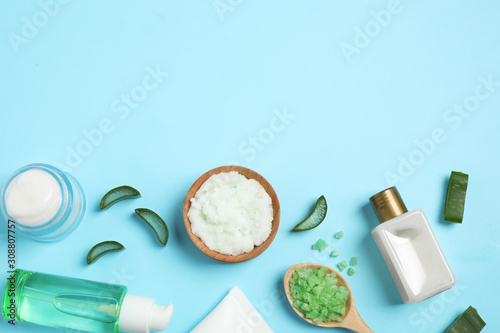 Flat lay composition with aloe vera and cosmetic products on light blue background. Space for text