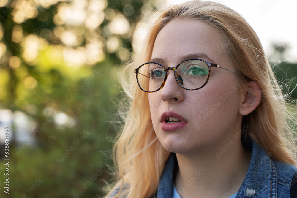 the portrait of blonde girl with smile and glasses. outdoor concept. the portrait of blonde girl with smile and glasses. outdoor concept.