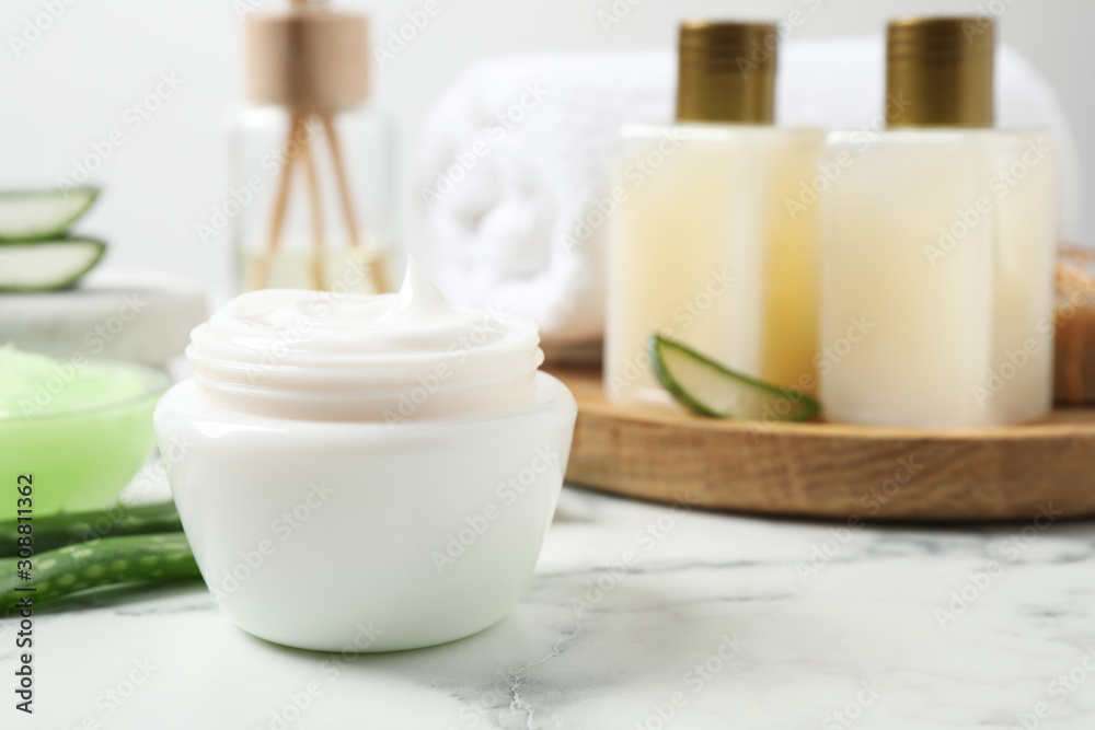 Open jar of aloe cream on white marble table. Organic cosmetics