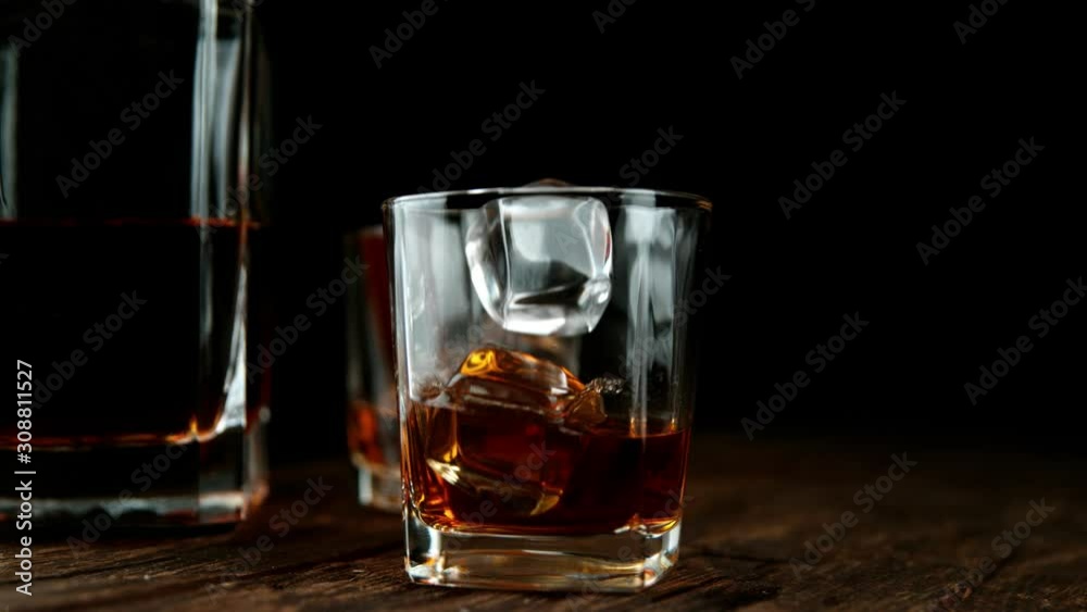 Super slow motion of falling ice cube into whiskey drink. Filmed on high speed cinema camera, 1000 fps. Super slow motion of falling ice cube into whiskey drink. Filmed on high speed cinema camera, 1000 fps.