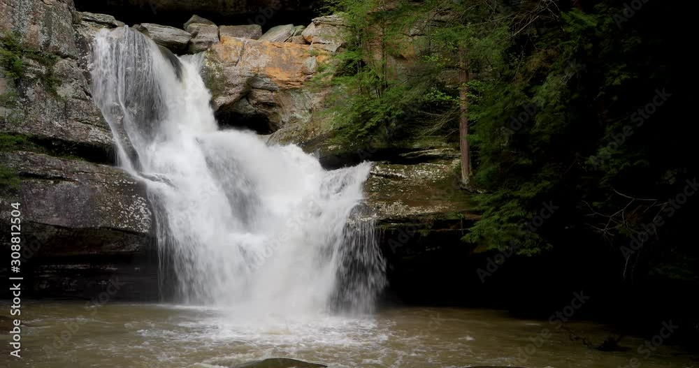 Water cascades and plunges over a sandstone cliff and down Cedar Falls, a beautiful waterfall in the Hocking Hills of Ohio, in this seamlessly looping video background Water cascades and plunges over a sandstone cliff and down Cedar Falls, a beautiful waterfall in the Hocking Hills of Ohio, in this seamlessly looping video background