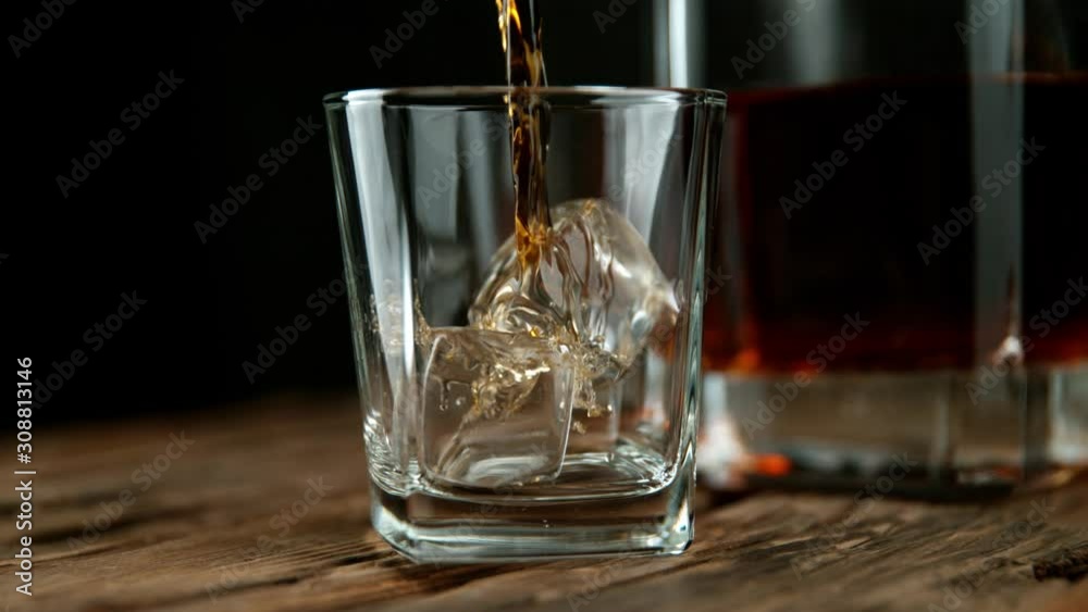 Super slow motion of pouring whiskey or rum with slide motion. Filmed on high speed cinema camera, 1000 fps Super slow motion of pouring whiskey or rum with slide motion. Filmed on high speed cinema camera, 1000 fps
