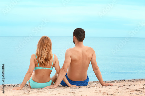 Happy couple sitting on bea...