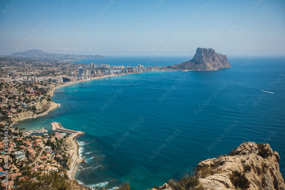 Beautiful super wide-angle aerial view of Calpe, Calp, Spain with harbor and skyline, Penon de Ifach mountain, beach and scenery beyond the city, seen from Mirador Monte Toix mountain viewpoint
