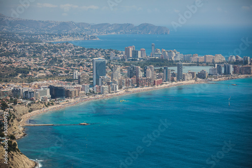 Beautiful super wide-angle aerial view of Calpe, Calp, Spain with harbor and skyline, Penon de Ifach mountain, beach and scenery beyond the city, seen from Mirador Monte Toix mountain viewpoint © tsuguliev