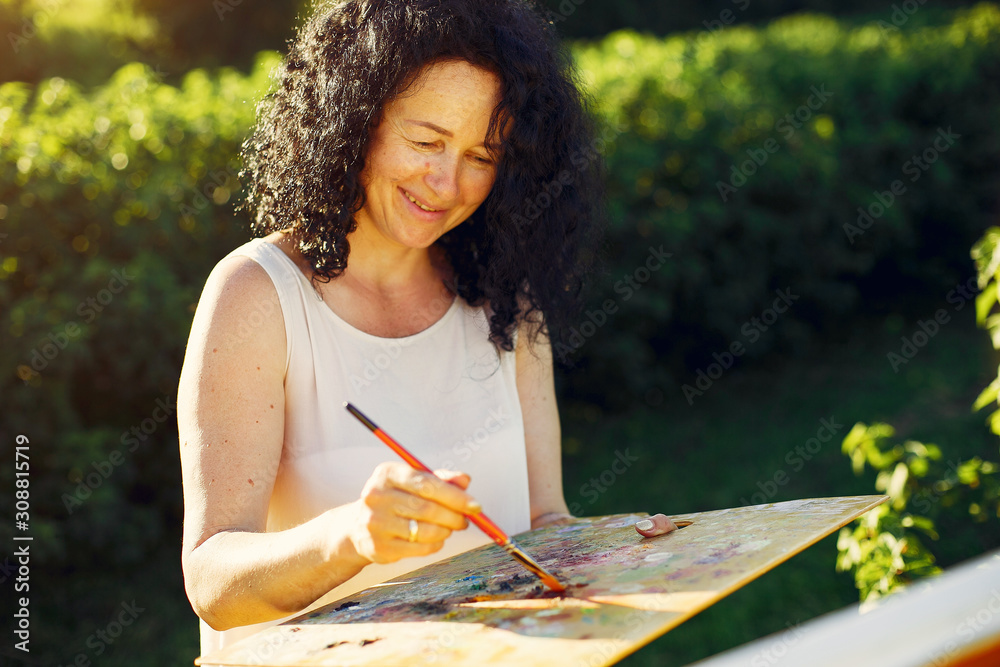 Woman artist painting with oil. Paints in a field Woman artist painting with oil. Paints in a field