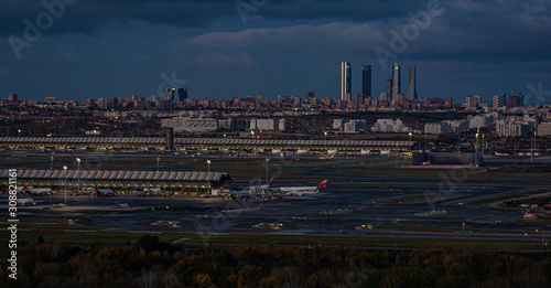 Night at the airport Adolfo Suarez Madrid Barajas overlooking the city skyline and the "four towers" with a cloudy sky