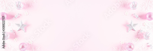 Christmas background concept. Top view of Christmas ball with snowflakes on light pink pastel background, ornament corner border frame header banner.
