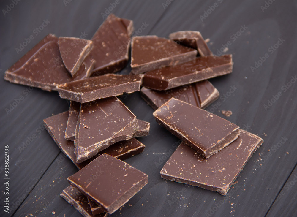 Broken dark chocolate on wooden background. Broken dark chocolate on wooden background.