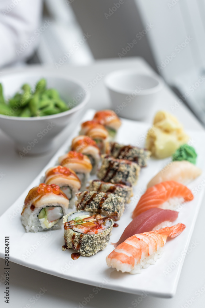Sushi Roll Set with Seafood on White Plate. Lunch in Japanese Restaurant Sushi Roll Set with Seafood on White Plate. Lunch in Japanese Restaurant