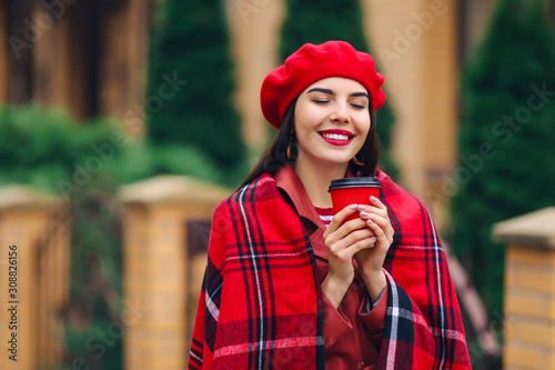 Beautiful young woman with cup of coffee outdoors on autumn day