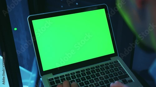 Wallpaper Mural Close-up of IT server expert running a neural network on mock-up laptop green monitor, programming backup code on server cabinet, working in professional data center. Torontodigital.ca