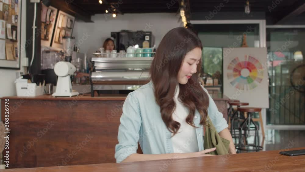 Cheerful Young Asian freelance lady working on laptop at coffee shop. Attractive Japanese businesswoman relax feeling happy in urban cafe or restaurant. Cheerful Young Asian freelance lady working on laptop at coffee shop. Attractive Japanese businesswoman relax feeling happy in urban cafe or restaurant.