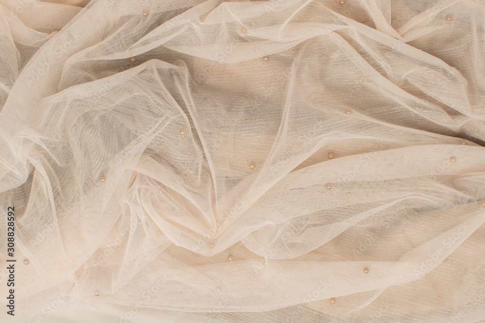 background from beige crumpled tulle with small beads. Abstract background, empty template. background from beige crumpled tulle with small beads. Abstract background, empty template.