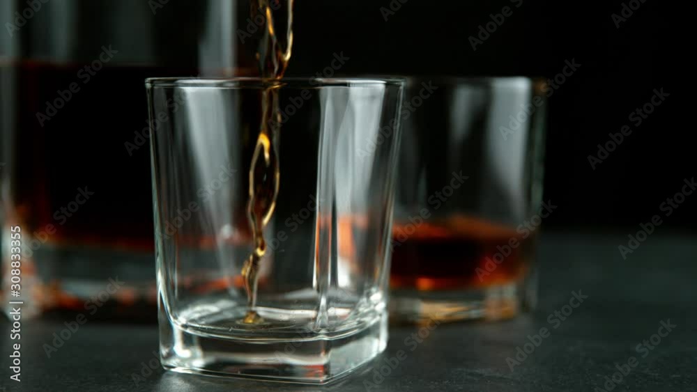 Super slow motion of pouring whiskey or rum with slide motion. Filmed on high speed cinema camera, 1000 fps Super slow motion of pouring whiskey or rum with slide motion. Filmed on high speed cinema camera, 1000 fps