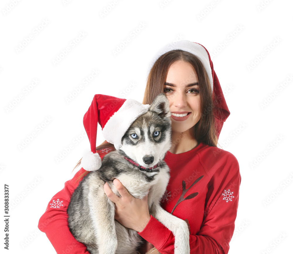 Cute woman with funny husky puppy in Santa Claus hats on white background