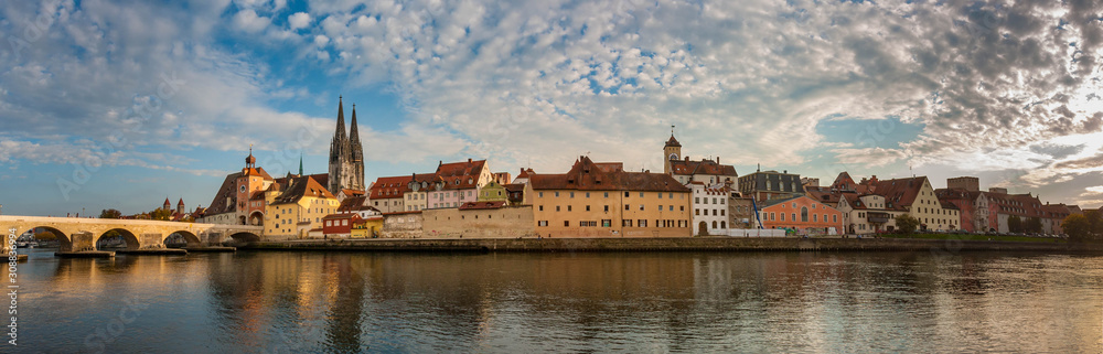 Panorama sunset view of the old city along the shore of Danube River, Regensburg, Germany.