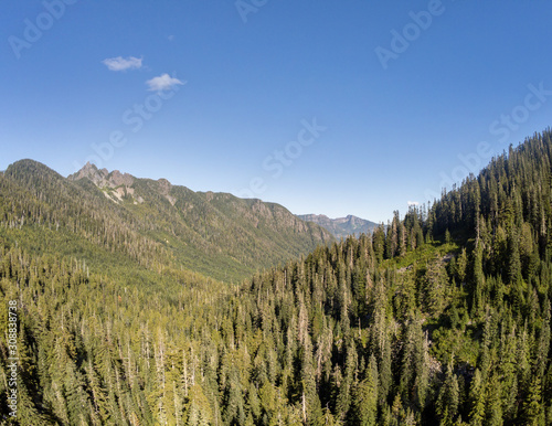 Secluded Kelcema Lake and the surrounding mountain and trees reflecting in the shaded water on a clear summer afternoon in the Mount Baker-Snoqualmie National Forest in Silverton Washington State