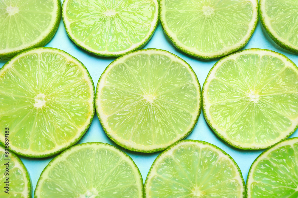 Juicy fresh lime slices on light blue background, flat lay