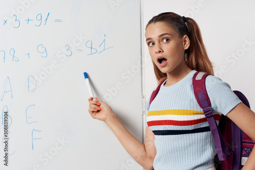 young student writing on blackboard
