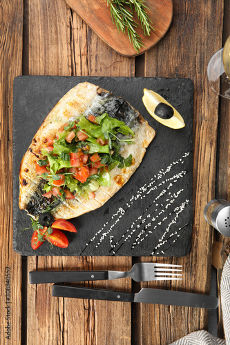 Delicious grilled fish served on wooden table, flat lay