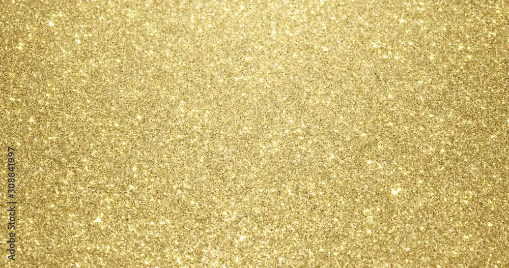 Gold glitter background with sparkling texture. Golden shimmering light, stars sequins sparks and glittering glow foil background