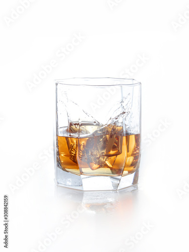 splash of whiskey with ice osolated on white photo