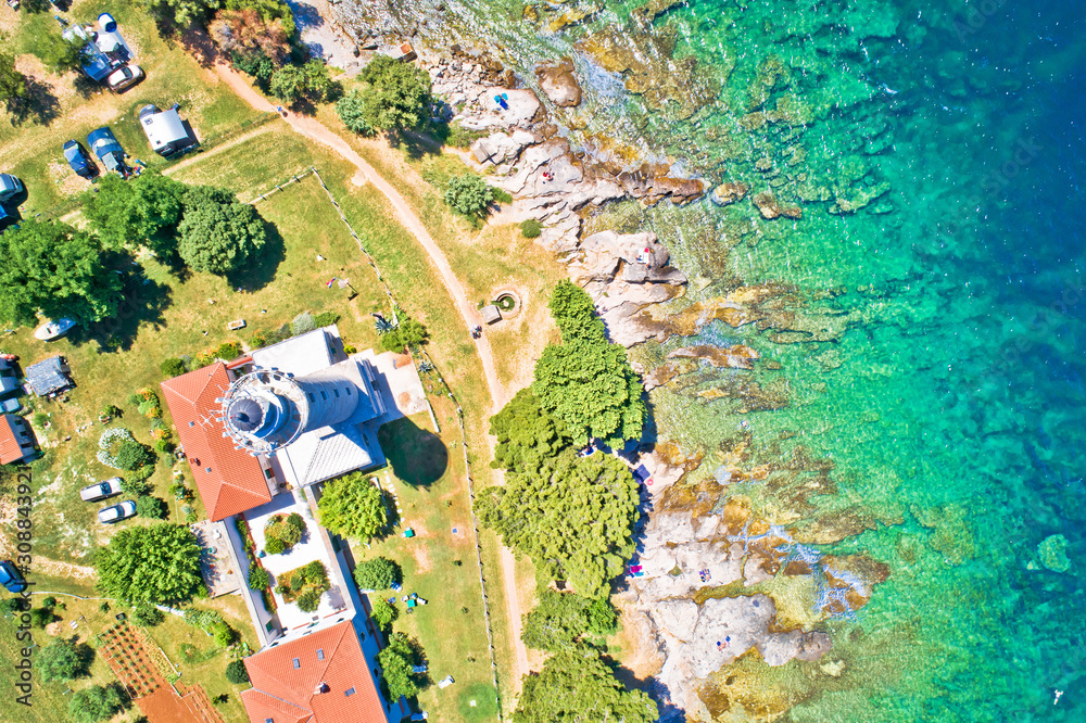 Savudrija lighthouse and turquoise crystal clear rocky beach aerial view