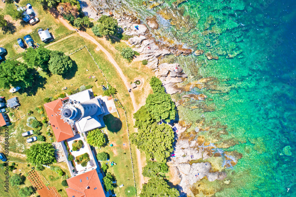 Fototapeta premium Savudrija lighthouse and turquoise crystal clear rocky beach aerial view