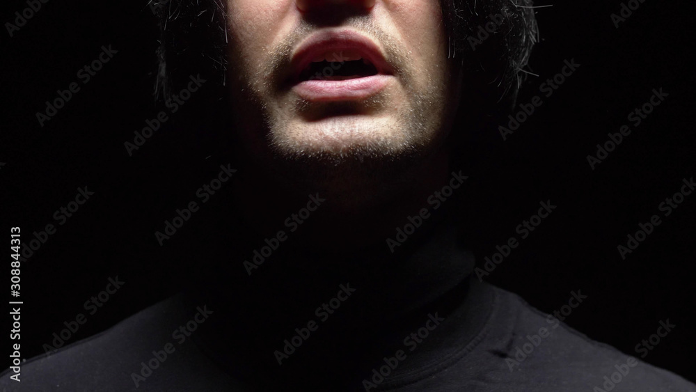 closeup. male mouth with crooked teeth screaming. Black background. closeup. male mouth with crooked teeth screaming. Black background.
