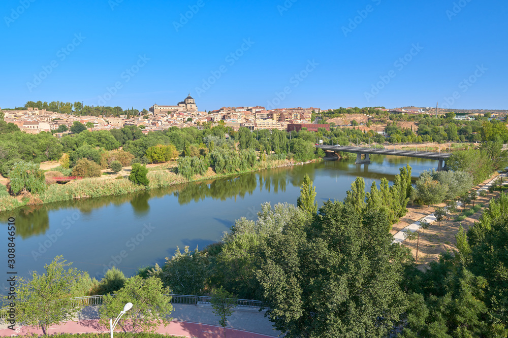 Obraz premium Landscape view of the Tagus river upon arrival in the city of Toledo with the Covachuela neighborhood and the Tavera Hospital in the background, Castilla la Mancha, Spain