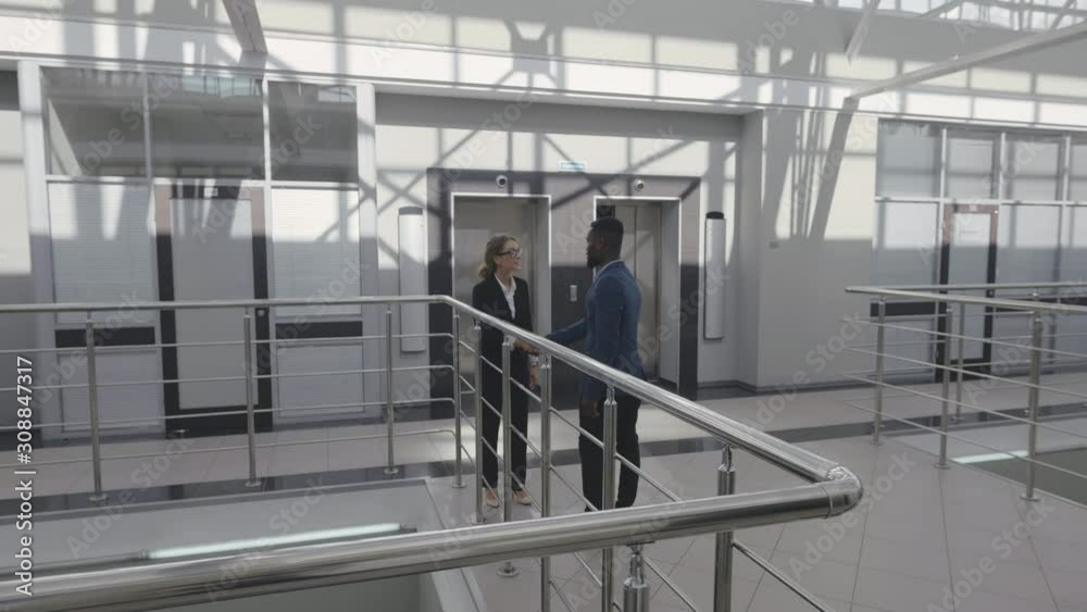 Office manager meeting client in hallway