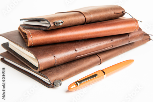 Leather-Bound Journals And An Orange Fountain Pen