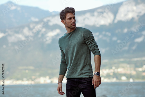 Handsome man in casual style clothes over blured mountain background photo