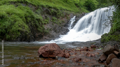 a waterfall in an Indian forest during the peak monsoon season photo