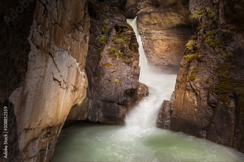 Water churns as it cascades down the rock ravine in Banff National Park, Alberta, Canada