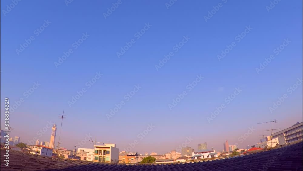 Beautiful sunrise and super wide top view in modern city over rooftops. Vivid colorful and clear blue skyline in Morning. Movement of clouds with calm feelings. With skyscrapers, houses. Timelapse.