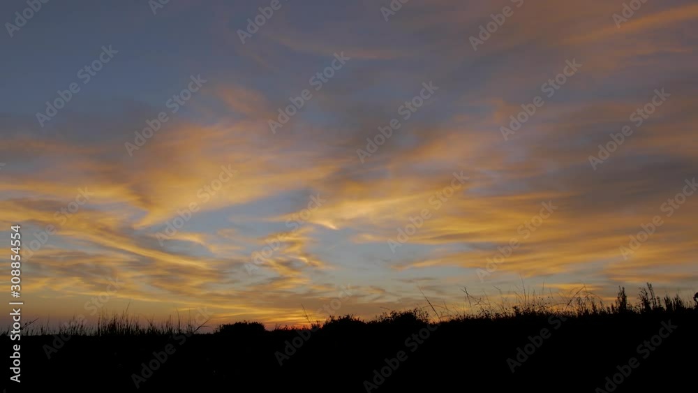 Vivid orange clouds as the sun rises over African grasslands, time lapse Vivid orange clouds as the sun rises over African grasslands, time lapse