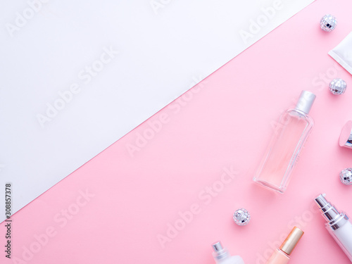 Makeup tools, cosmetics, perfume, creams bottles, Christmas balls on pink white