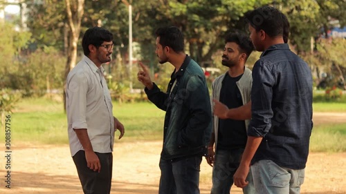 Group of young bullies or men attacking and abusing a person - youth threating an innocent man - concept of college bully and teasing at outdoor.