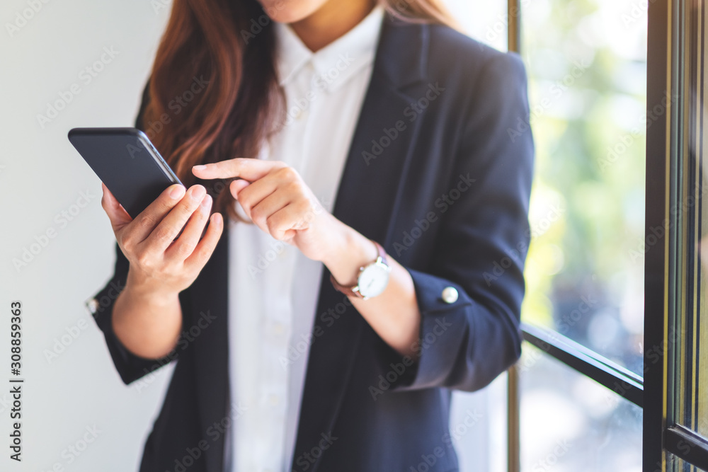 Closeup image of a businesswoman holding and using mobile phone