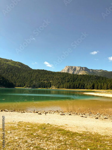 Black lake in Montenegro. Beautiful lake on the background of forest and mountains.