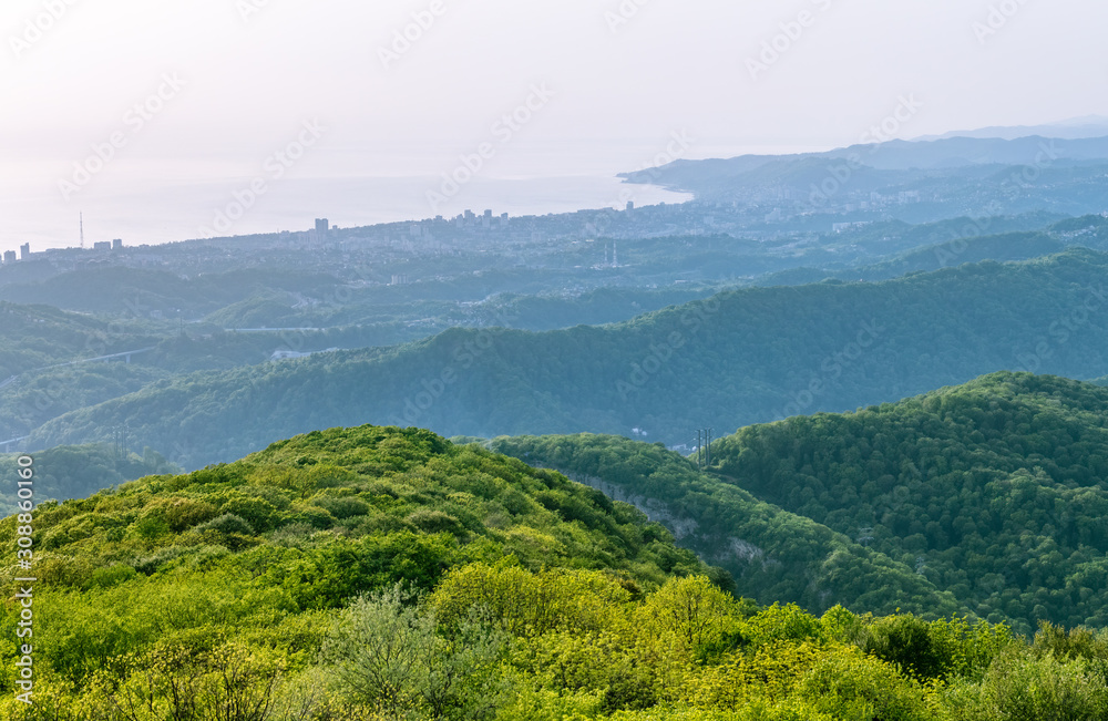 Naklejka premium Layers of mountains and the sea in a haze in the light of the sunshine. View from Mount Akhun, Sochi, Russia.