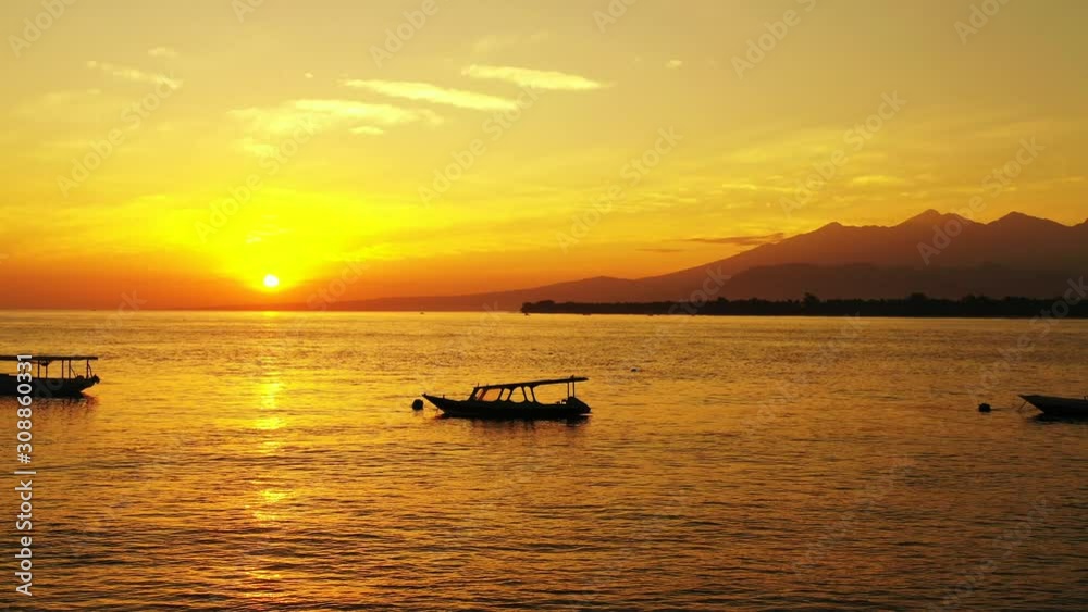 Majestic golden seascape, tropical ocean with boats and mountain island in the background Majestic golden seascape, tropical ocean with boats and mountain island in the background