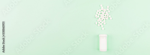 White pills on a pastel green background. Flat lay, top view, overhead, mockup, template, copy space. Pharmacy and medical concept