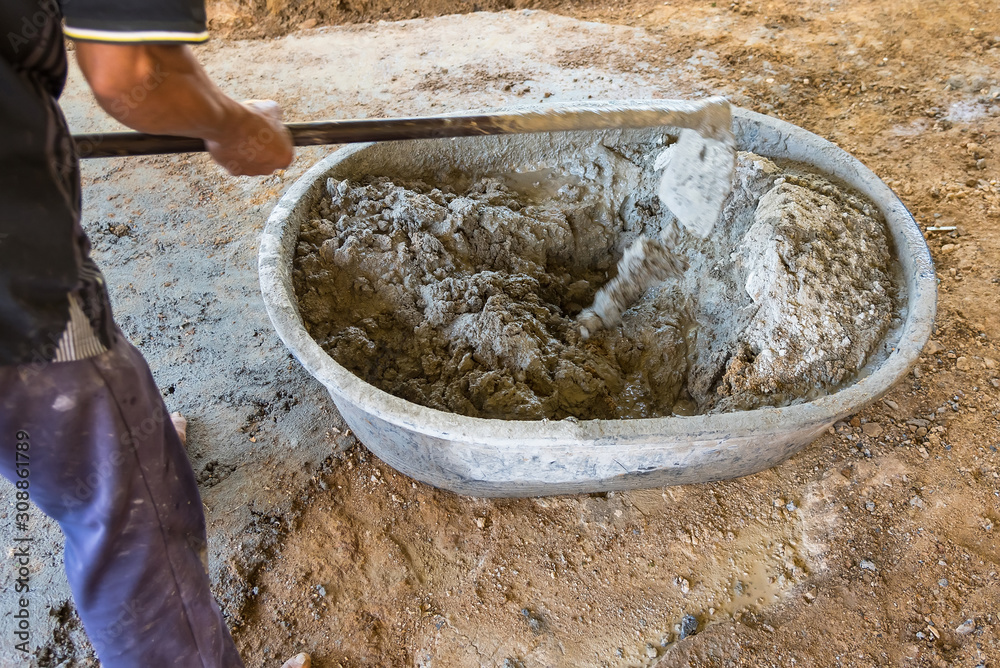 Worker Mixed Cements in Basin Mixer with Hoe in construction site. Worker Mixed Cements in Basin Mixer with Hoe in construction site.