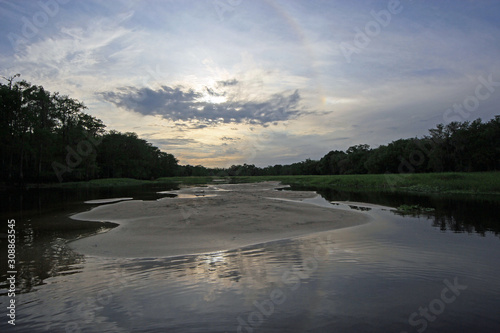 Colorful sunset relfected on calm water of Fisheating Creek  Florida on tranquil spring afternoon.