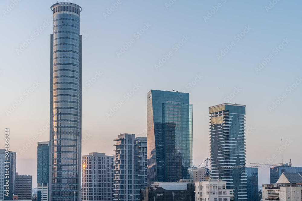 Fototapeta premium Aerial sunset panorama view of Tel Aviv financial district, Givatayim, , Givat Amal, Tel Binyamin, Givat Rambam, Montefiore with skyscrapers and cranes working on new construction in Israel
